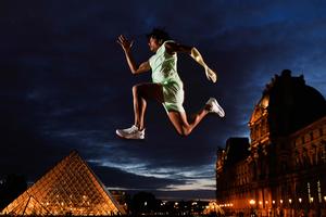 L'athlète paralympique de triple saut Arnaud Assoumani pose devant la Pyramide du Louvre conçue par Ieoh Ming Pei, le 20 avril 2024. 